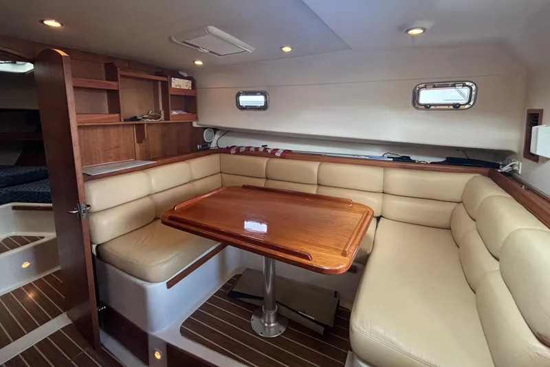 Slide: The Image of 2005 Mainship Pilot 34 interior with dining area, steps, and compact kitchen. - 17