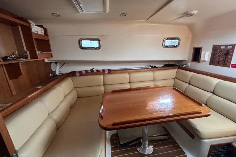Slide: The Image of Luxurious interior of 2005 Mainship Pilot 34 with cozy seating and wooden table. - 18