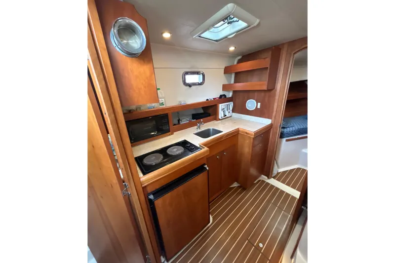 Slide: The Image of 2005 Mainship Pilot 34 interior with kitchenette, sink, and shower area. - 21