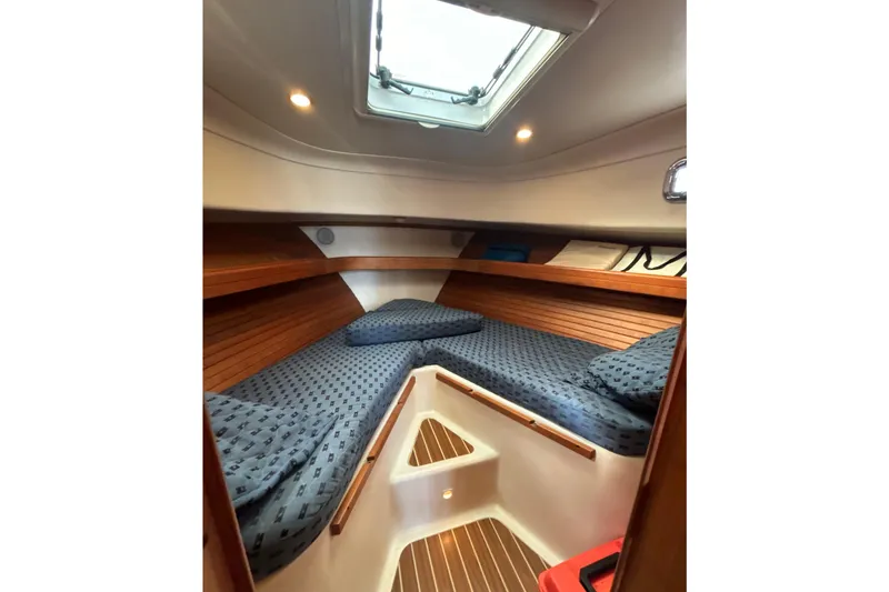 Slide: The Image of 2005 Mainship Pilot 34 interior kitchen with wood cabinetry, stove, sink, and compact fridge. - 22