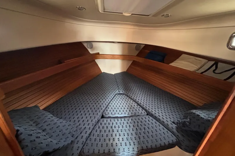 Slide: The Image of 2005 Mainship Pilot 34 cabin interior with cozy bedding and wooden accents. - 23