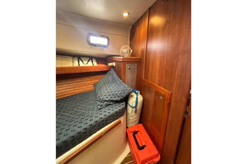 Slide: The Image of 2005 Mainship Pilot 34 cabin interior with wood paneling and patterned bedding. - 25