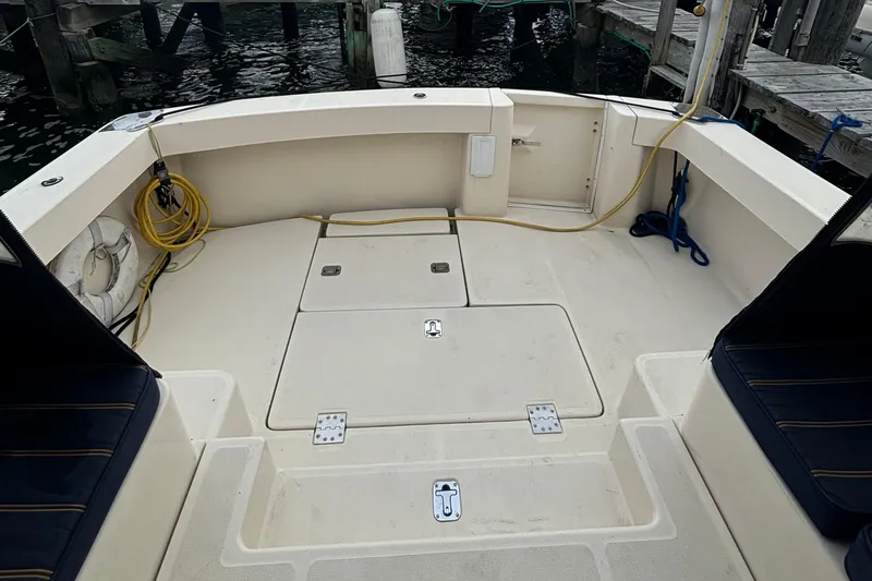 Slide: The Image of 2005 Mainship Pilot 34 docked, showcasing spacious deck and marina surroundings. - 8