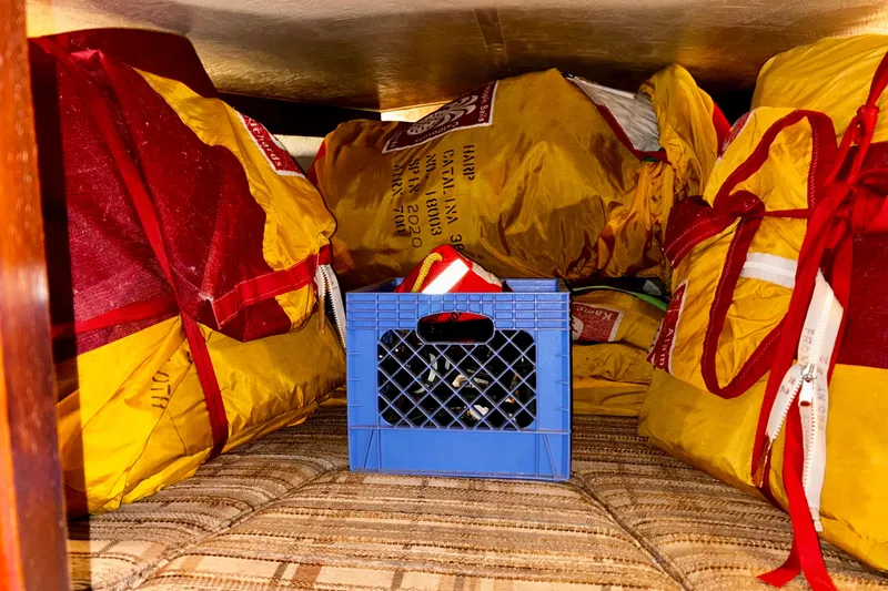 Slide: The Image of Vee Berth area, 'The Garage', showing some sail inventory. - 13