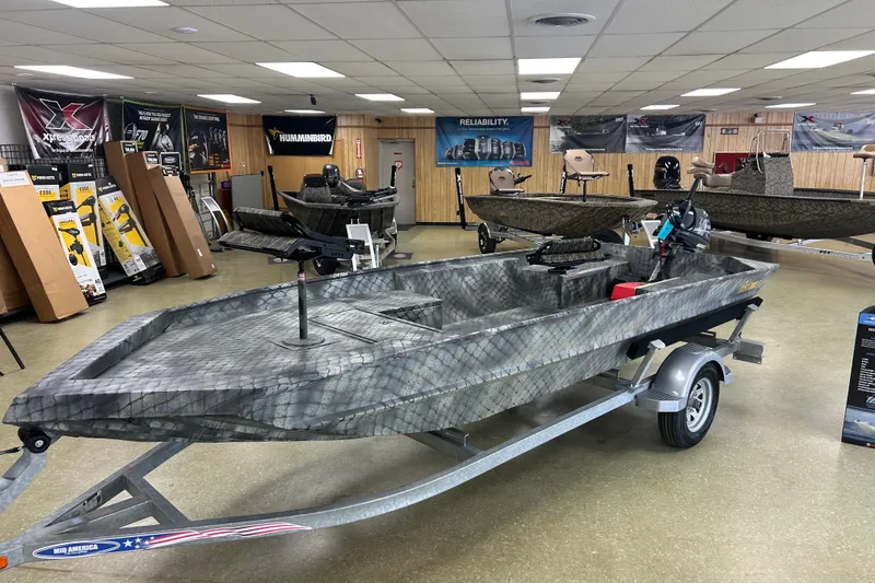 Slide: The Image of 2025 WeldBilt 1652 boat on trailer in showroom, surrounded by marine equipment. - 4
