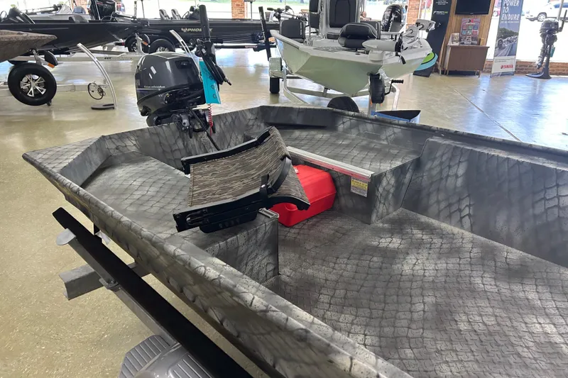 Slide: The Image of 2025 WeldBilt 1652 boat with camouflage pattern and outboard motor in showroom. - 6