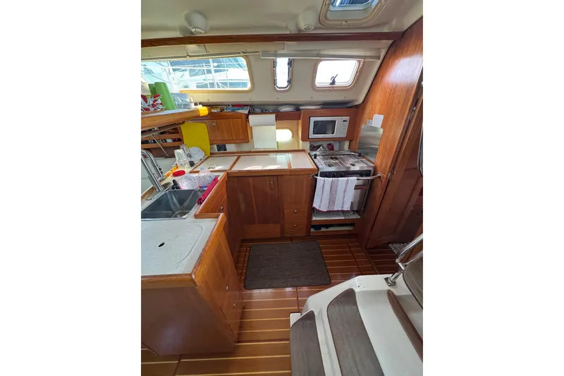 Slide: The Image of Interior of a 2002 Hunter 410 sailboat kitchen with wooden cabinetry and appliances. - 5