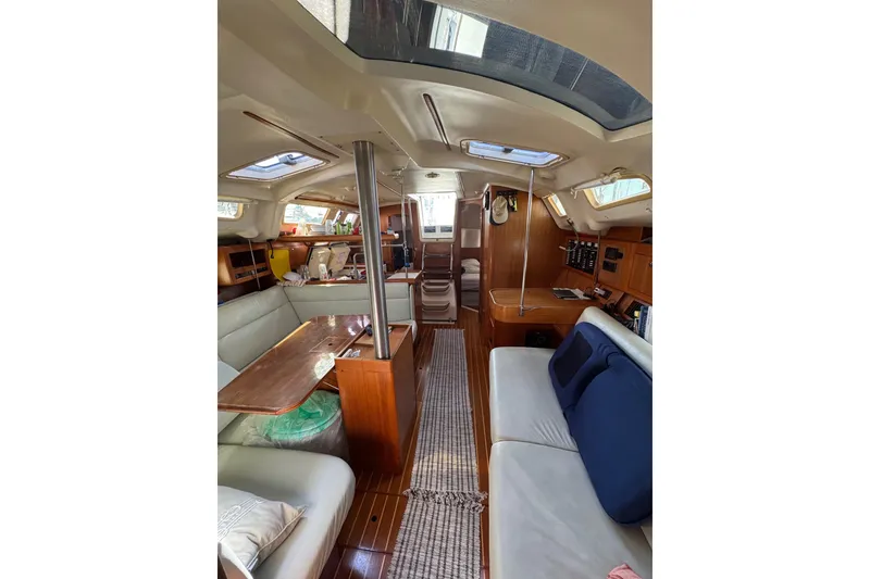 Slide: The Image of Interior of 2002 Hunter 410 sailboat with cozy seating and wooden finishes. - 6