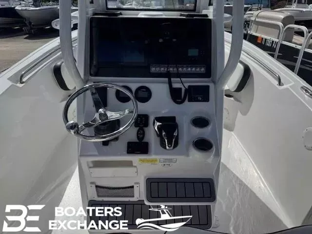 Slide: The Image of 2023 Tidewater 232 CC Adventure boat console with steering wheel and controls. - 7