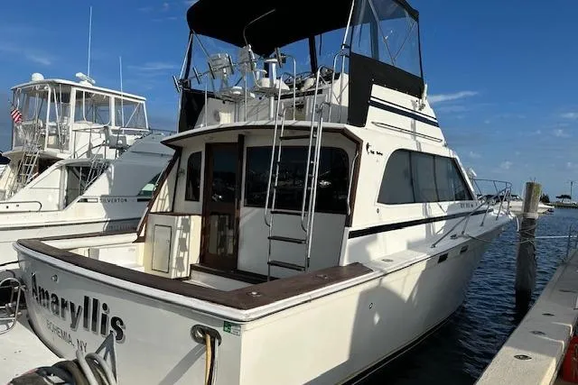 The Image of 1986 Egg Harbor 37 Convertible yacht docked at marina under clear blue sky. - 0