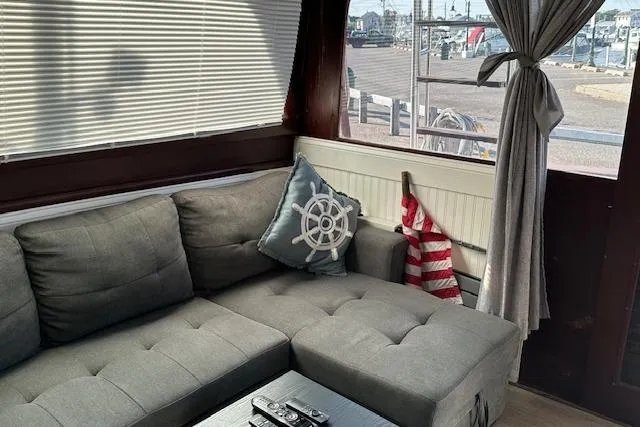 Slide: The Image of Interior of 1986 Egg Harbor 37 Convertible with gray sofa, nautical decor, and marina view. - 14