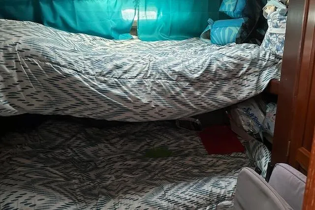 Slide: The Image of Cozy cabin interior of 1986 Egg Harbor 37 Convertible with bunk beds and teal curtains. - 21