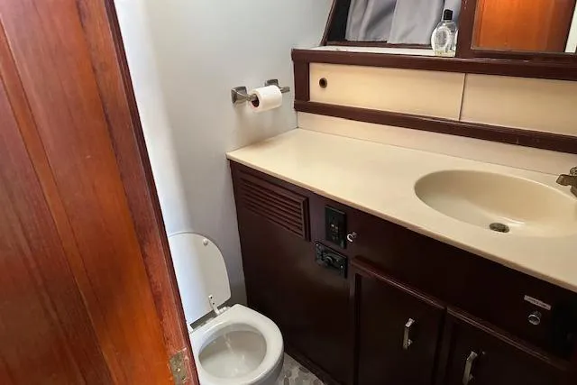 Slide: The Image of 1986 Egg Harbor 37 Convertible bathroom with sink, toilet, and wooden cabinetry. - 25