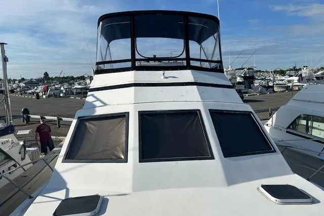 Slide: The Image of 1986 Egg Harbor 37 Convertible yacht docked at marina, showcasing sleek design and spacious deck. - 3