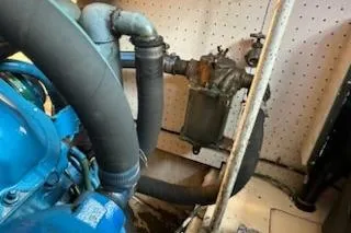 Slide: The Image of Engine compartment of a 1986 Egg Harbor 37 Convertible boat, showing hoses and mechanical components. - 39