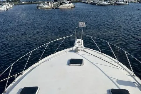 Slide: The Image of 1986 Egg Harbor 37 Convertible yacht on calm waters, marina in background. - 4
