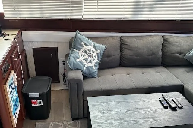 Slide: The Image of Interior of 1986 Egg Harbor 37 Convertible with gray sofa, nautical pillow, and blinds. - 8