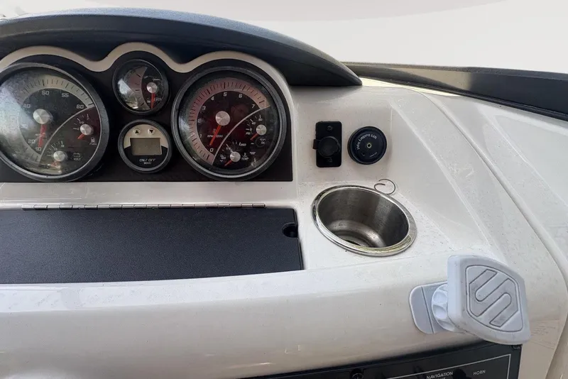 Slide: The Image of Dashboard of 2016 Bayliner 215 Deck Boat with gauges and cup holder. - 23