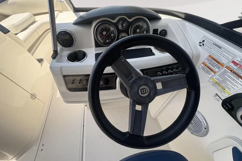 Slide: The Image of 2016 Bayliner 215 Deck Boat steering console with gauges and controls. - 26