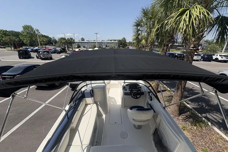 Slide: The Image of 2016 Bayliner 215 Deck Boat with black canopy in a parking lot. - 9