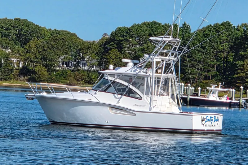 Slide: The Image of 2022 Albemarle 36 Express boat cruising on a serene lake with lush green trees. - 2