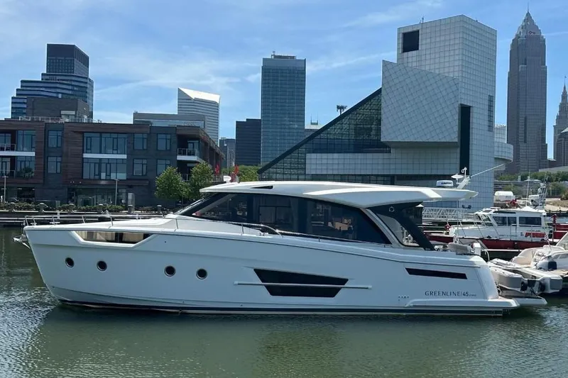 Slide: The Image of 2024 Greenline 45 Coupe Hybrid yacht docked in urban marina with city skyline. - 0