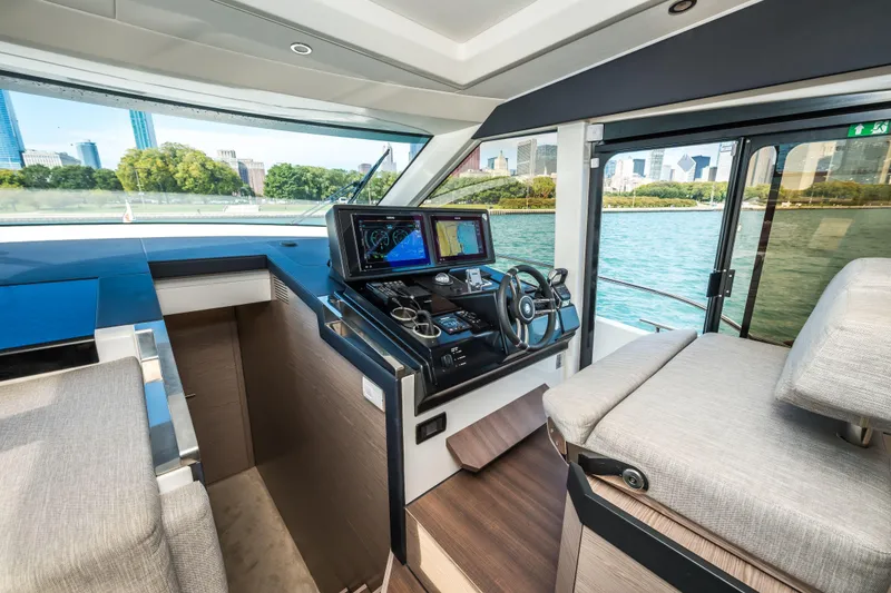 Slide: The Image of 2024 Greenline 45 Coupe Hybrid yacht interior with modern helm and cityscape view. - 12