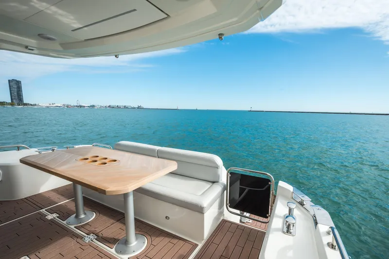 Slide: The Image of 2024 Greenline 45 Coupe Hybrid yacht deck with ocean view and seating area. - 19