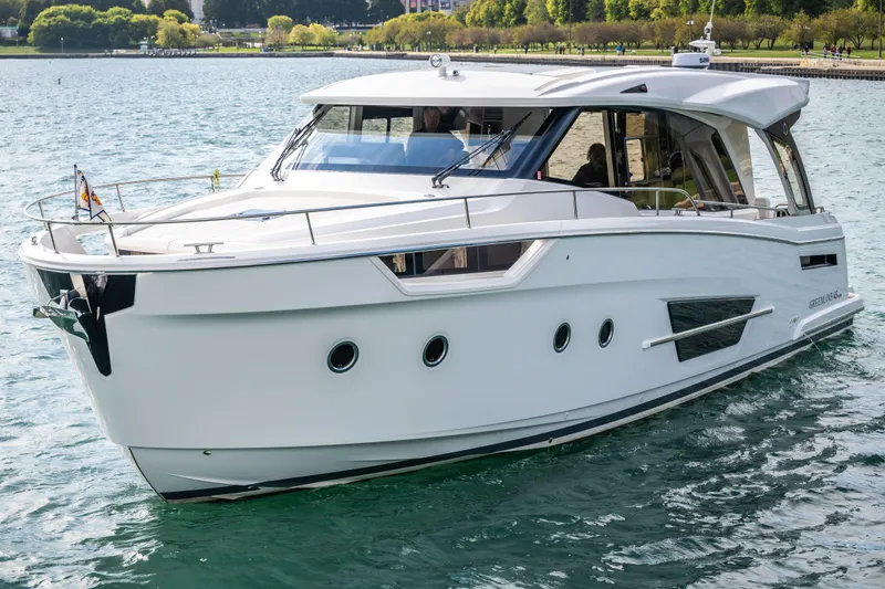 Slide: The Image of 2024 Greenline 45 Coupe Hybrid yacht cruising on a serene lake. - 2