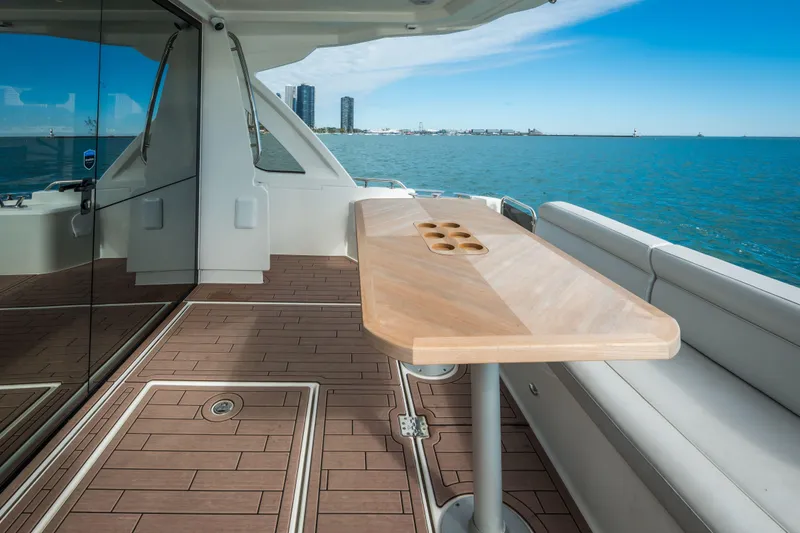 Slide: The Image of 2024 Greenline 45 Coupe Hybrid yacht deck with wooden table, ocean view. - 20