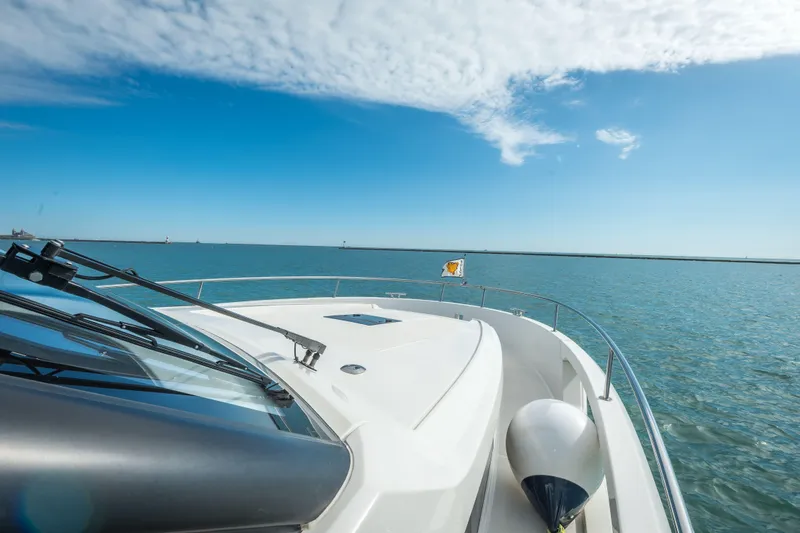 Slide: The Image of 2024 Greenline 45 Coupe Hybrid yacht cruising on open water under a clear blue sky. - 22