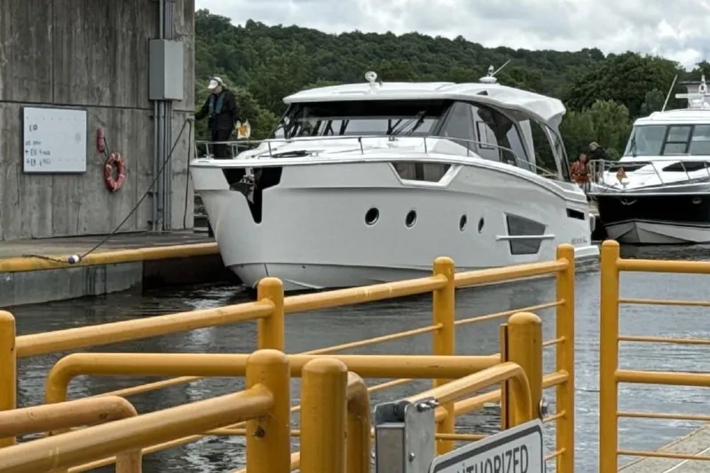 Slide: The Image of 2024 Greenline 45 Coupe Hybrid yacht navigating a lock, surrounded by lush greenery. - 23