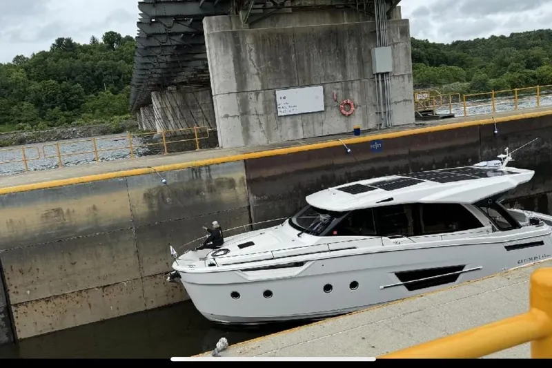 Slide: The Image of 2024 Greenline 45 Coupe Hybrid yacht navigating a lock under a bridge. - 24