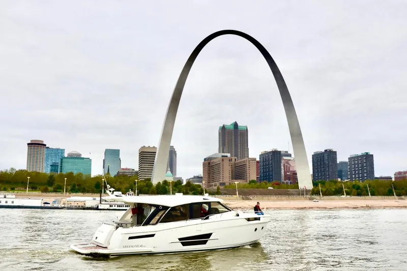 Slide: The Image of 2024 Greenline 45 Coupe Hybrid yacht cruising near iconic city arch and skyline. - 25