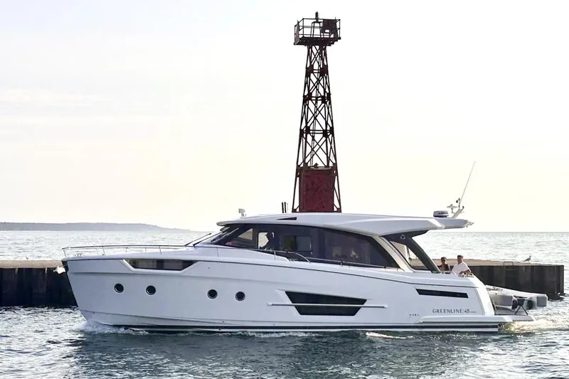 Slide: The Image of 2024 Greenline 45 Coupe Hybrid yacht cruising near a lighthouse on calm waters. - 26