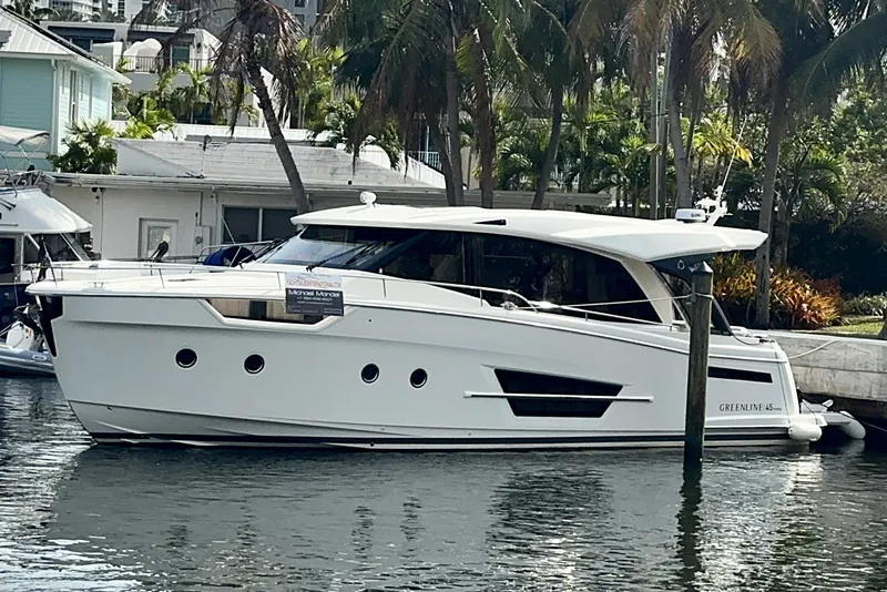 Slide: The Image of 2024 Greenline 45 Coupe Hybrid yacht docked by palm trees. - 29