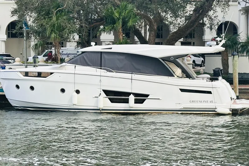 Slide: The Image of 2024 Greenline 45 Coupe Hybrid yacht docked by palm trees. - 4