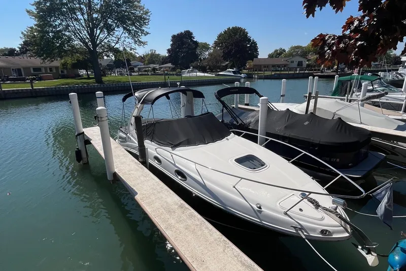 Slide: The Image of 2006 Sea Ray 260 Sundancer docked in a serene marina setting. - 1