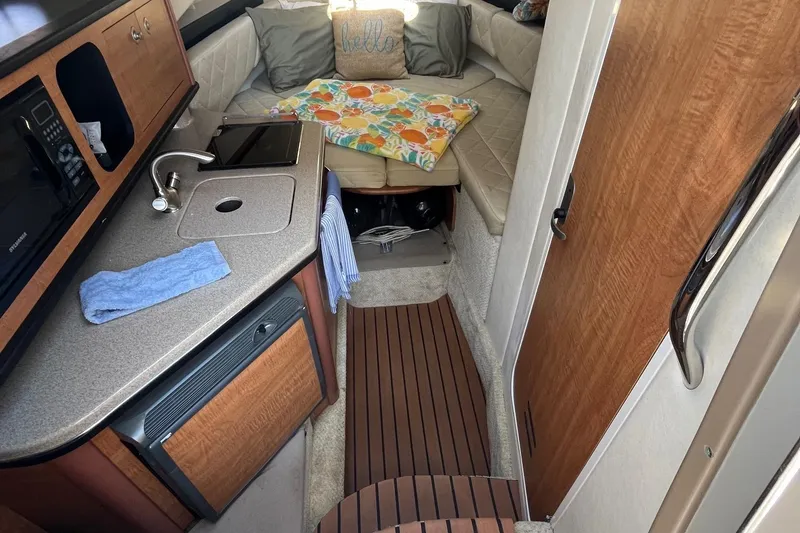 Slide: The Image of 2006 Sea Ray 260 Sundancer cabin interior with kitchenette and seating area. - 10
