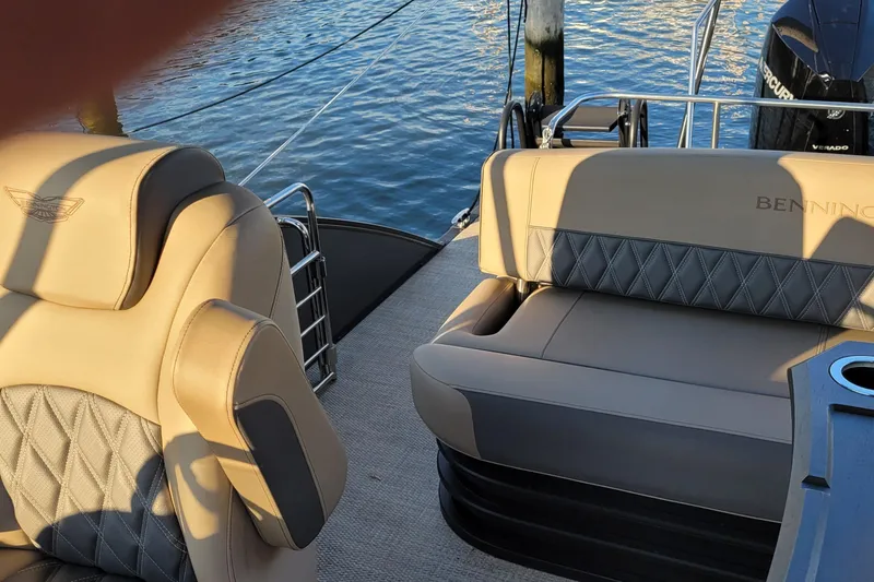 Slide: The Image of 2024 Bennington 24LXSSB boat interior with luxurious seating and water view. - 17