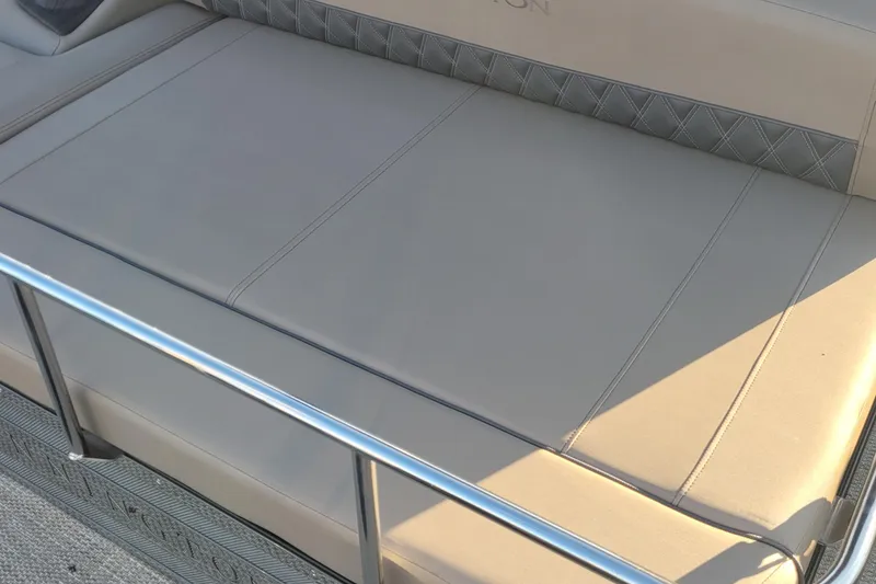 Slide: The Image of 2024 Bennington 24LXSSB boat seat with beige upholstery and metal railing. - 25