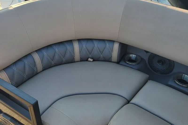 Slide: The Image of 2024 Bennington 24LXSSB boat interior with cushioned seating and cup holders. - 28