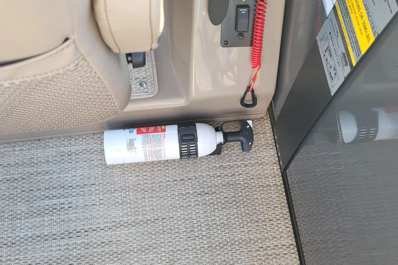 Slide: The Image of Fire extinguisher on 2024 Bennington 24LXSSB boat, placed near control panel. - 40