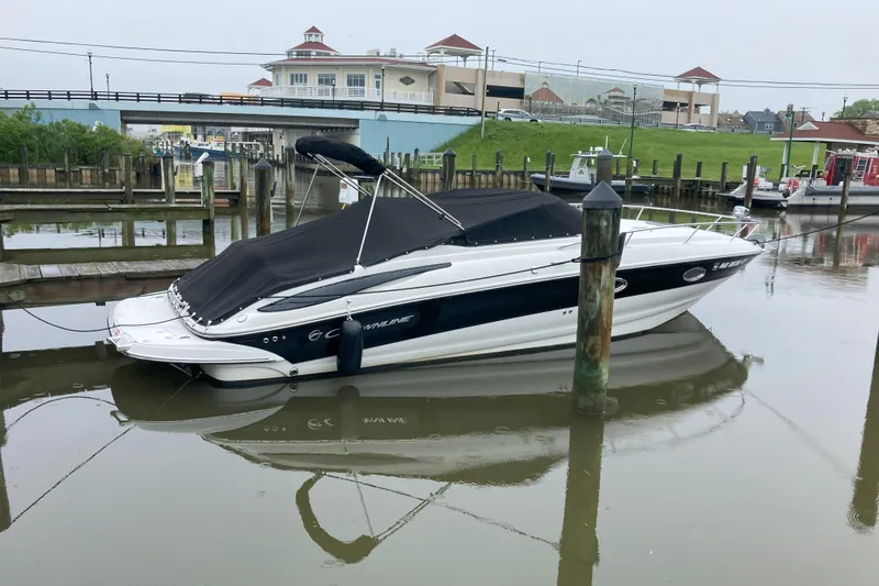 Slide: The Image of 2011 Crownline 286 SC boat docked in a marina with a black cover. - 10