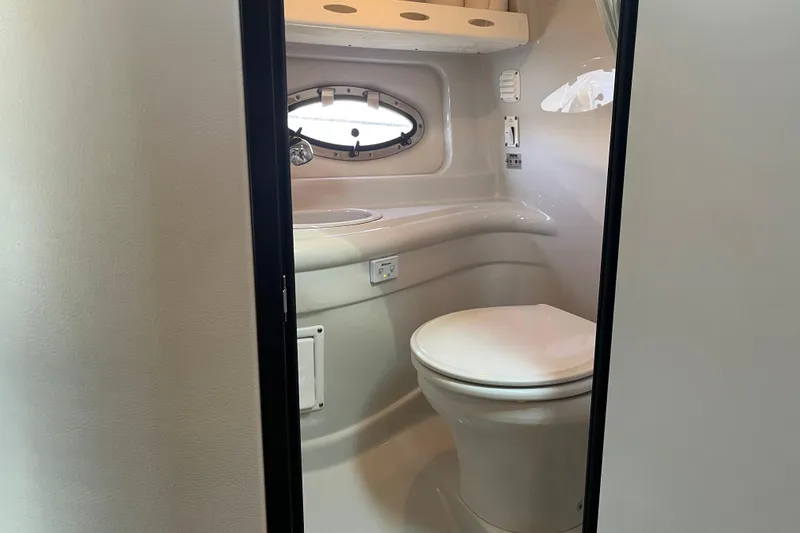 Slide: The Image of 2011 Crownline 286 SC boat bathroom with toilet and porthole window. - 14