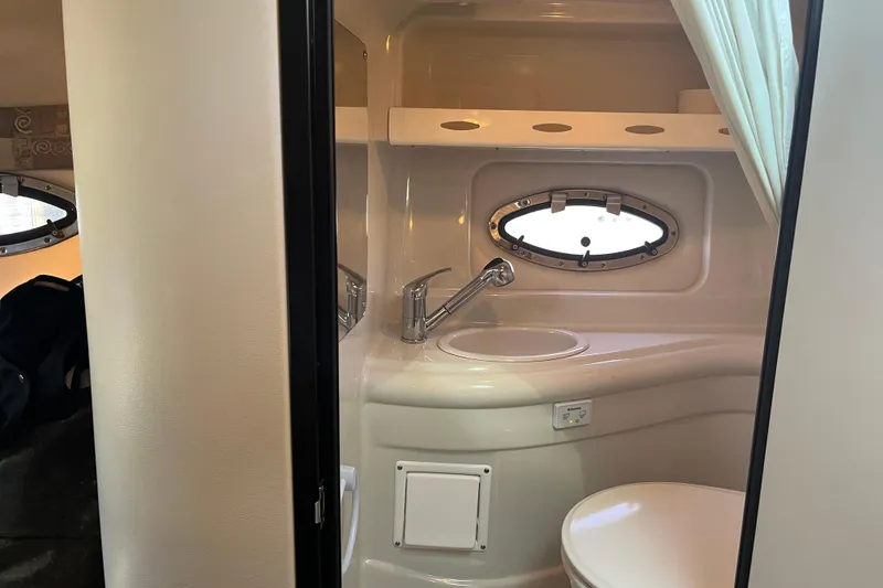 Slide: The Image of Interior of 2011 Crownline 286 SC boat bathroom with sink and porthole window. - 15