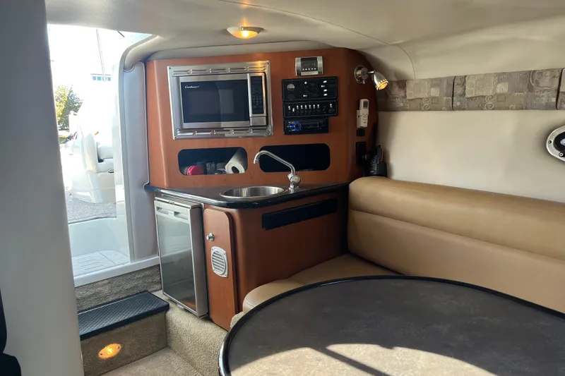 Slide: The Image of Interior of 2011 Crownline 286 SC boat with kitchenette and seating area. - 16