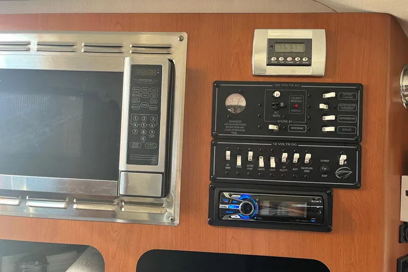 Slide: The Image of Control panel and microwave in 2011 Crownline 286 SC boat interior. - 17
