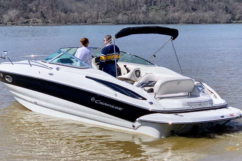 Slide: The Image of 2011 Crownline 286 SC boat on a calm lake with two people onboard. - 19