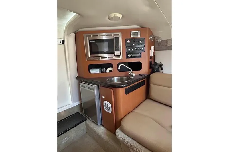 Slide: The Image of Compact kitchen area in 2011 Crownline 286 SC boat with microwave, sink, and mini-fridge. - 4